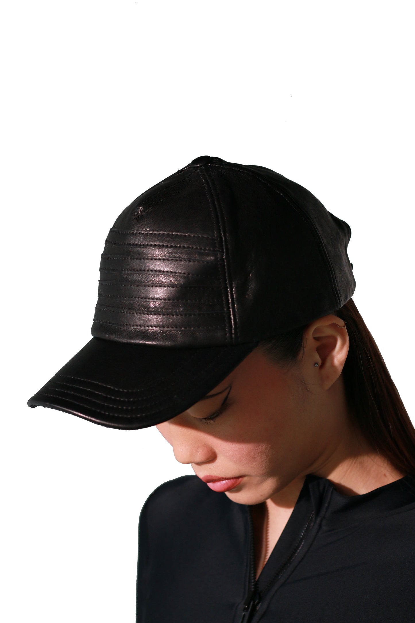 A women wearing a black lamb skin hat with a sharp, modern silhouette design.